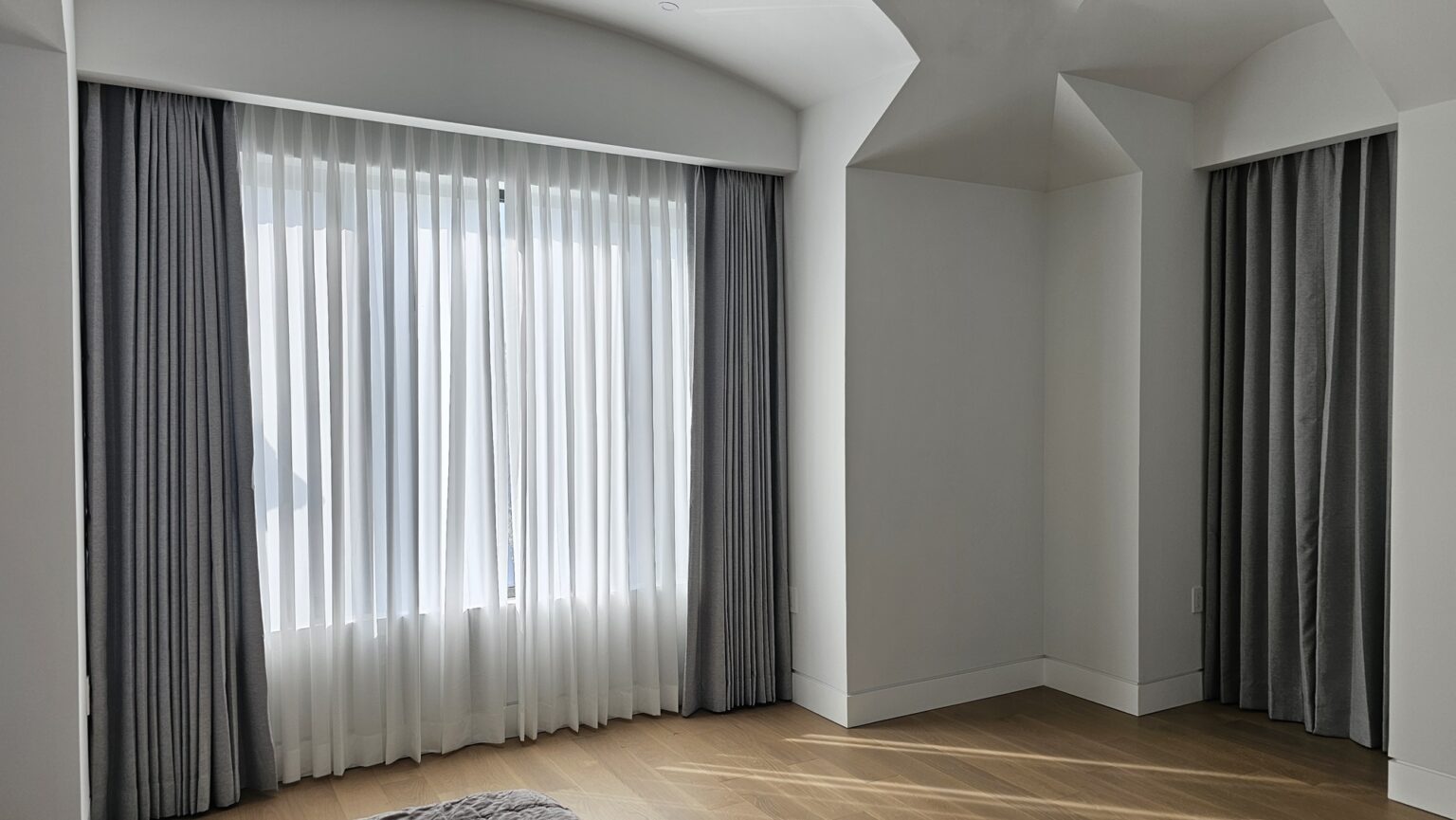 Custom drapery panels in a living room on floor to ceiling windows in a Bergen County home