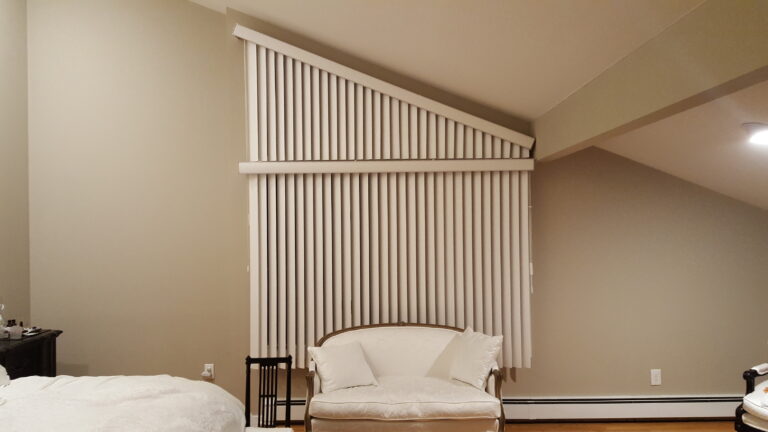 Vertical sheer panels custom cut to follow a sloped angled window wall