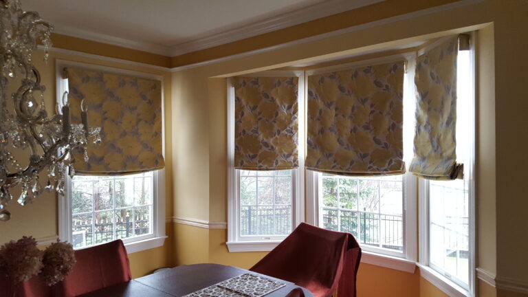Roman shades in a dining room across a bay window in a Bergen County home