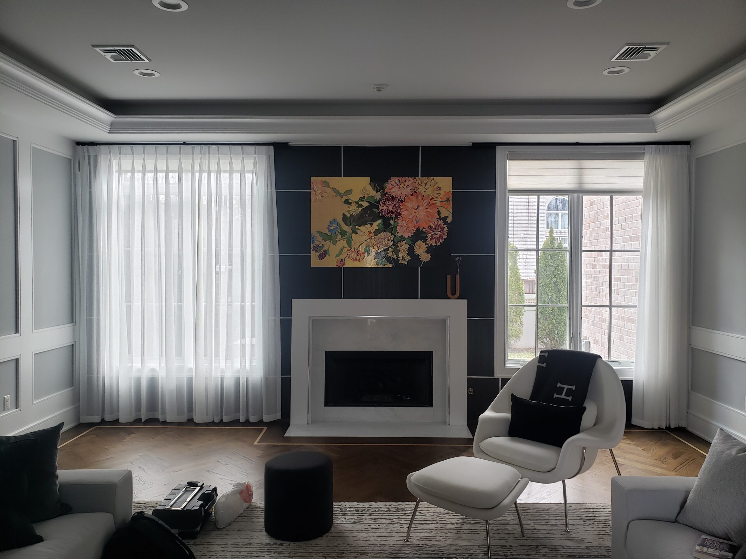 Sheer drapery either side of a fireplace in a living room
