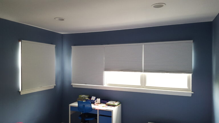 Room-darkening honeycomb shades in Oxford across a bedroom window