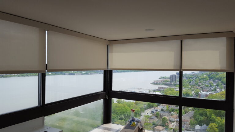Oatmeal woven fabric roller shades in a tall-windowed living room