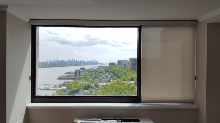 Roller shades in a living room on floor to ceiling windows in a Bergen County home