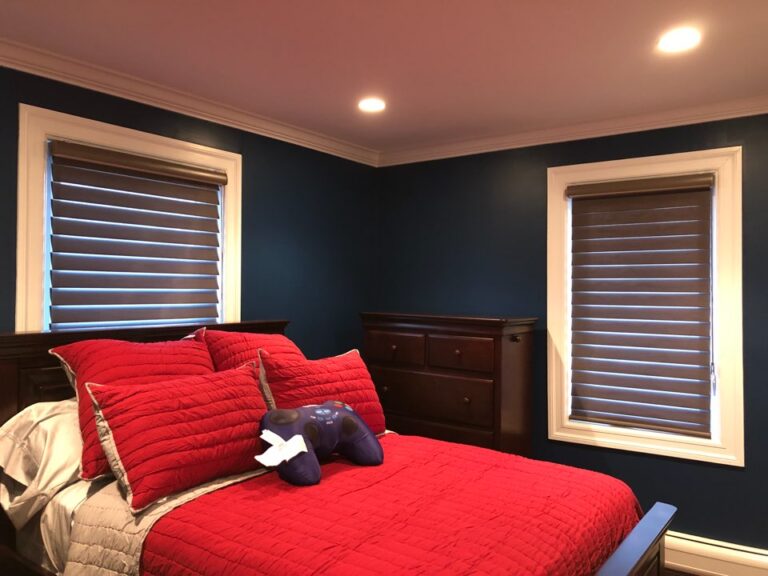 Coffee coloured zebra shades on two bedroom windows against a deep navy wall