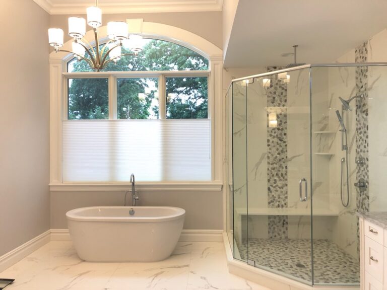 A honeycomb shade in a bathroom, letting daylight in above while keeping the lower window covered