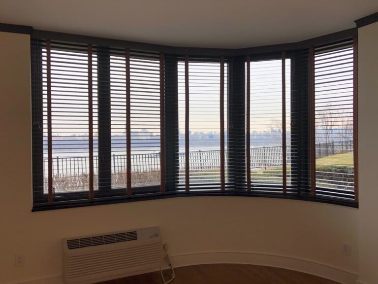 Dark stained Parkland wood blinds in a bay window overlooking the water