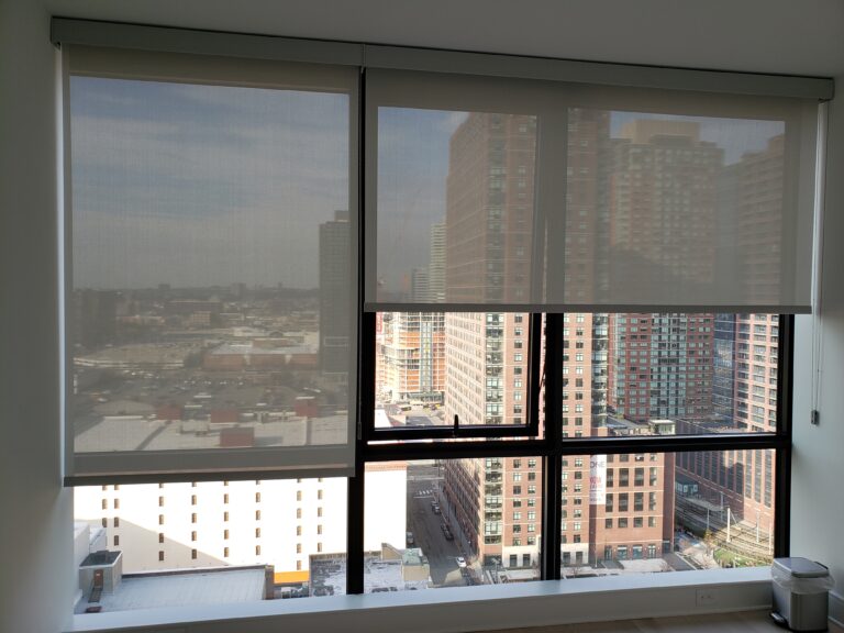 Roller shades in a living room on floor to ceiling windows in a Bergen County home