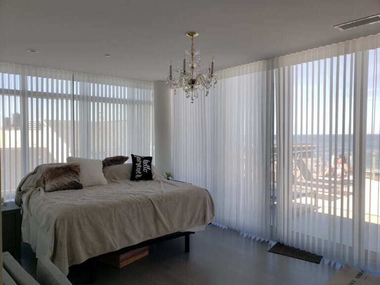 Vertical privacy sheers in a bedroom on floor to ceiling windows in a Bergen County home