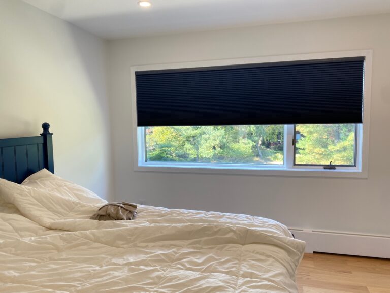 A room with cellular honeycomb shades, shown at different fabric opacities