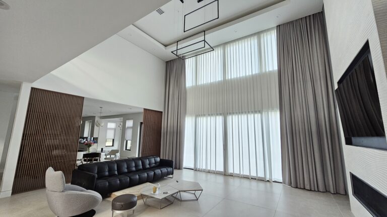 Sheer and opaque drapery layered in a double height living room