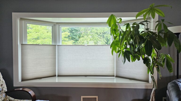 Cellular shades in a home office bay window