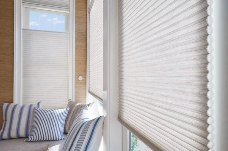 Close detail of a cellular honeycomb shade drawn across a window seat
