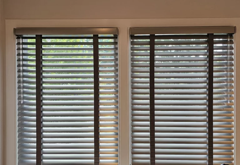 Gray 2-inch aluminum blinds with dark cloth tape and matching valances on a pair of home office windows